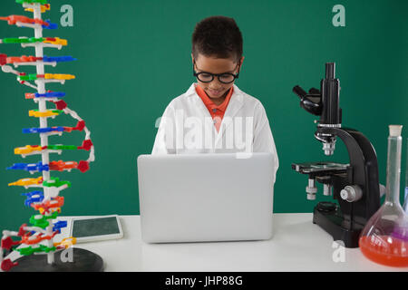 Schoolboy using laptop in laboratory Stock Photo