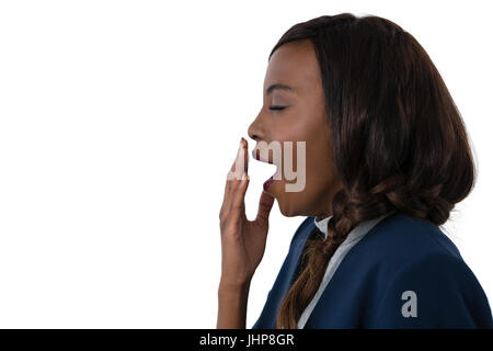 Side view of businesswoman yawning against white background Stock Photo