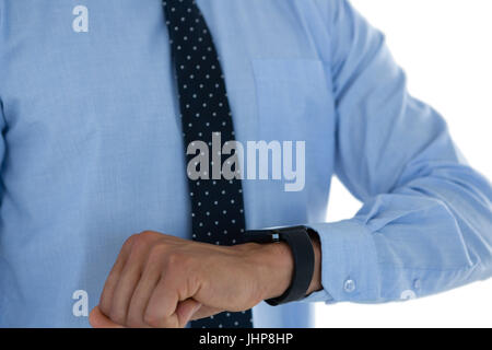 Mid section of businessman with smartwatch standing against white background Stock Photo