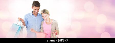 Digital composite of Couple shopping with bags and sparkling lights bokeh transition Stock Photo