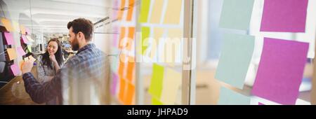 Digital composite of Millennial team writing on sticky notes with sticky note transition Stock Photo