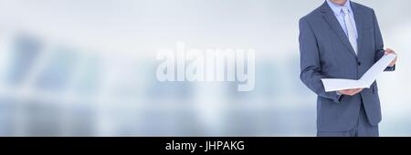 Digital composite of Businessman holding files and folders with blurred background Stock Photo