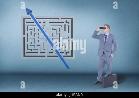 Digital composite of Man looking through binoculars against blue background with a maze Stock Photo