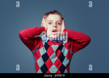 scared boy isolated against grey background Stock Photo