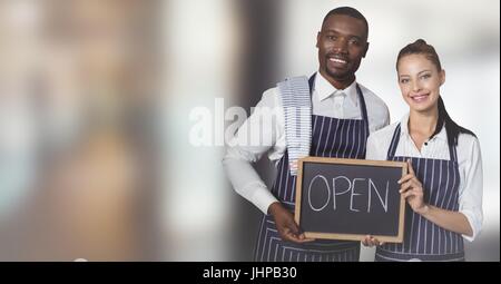 Digital composite of Restaurant owners with chalkboard against blurry hallway Stock Photo