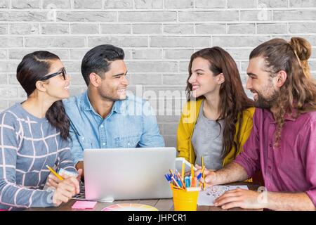 Digital composite of Happy business people at a desk using a computer against white wall Stock Photo