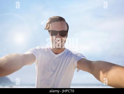 Digital composite of Man taking casual selfie photo in front of sea sky Stock Photo