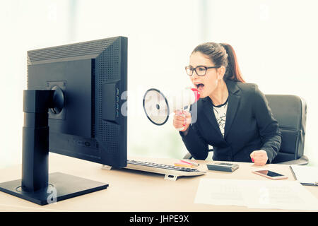 Businesswoman yelling through a megaphone Stock Photo
