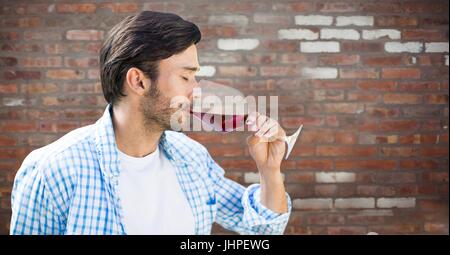 Digital composite of Man tasting wine against red brick wall Stock Photo