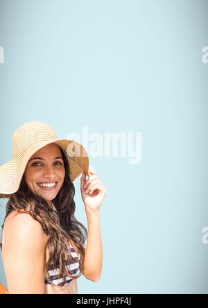 Digital composite of Millennial woman sun hat and bikini against light blue background Stock Photo