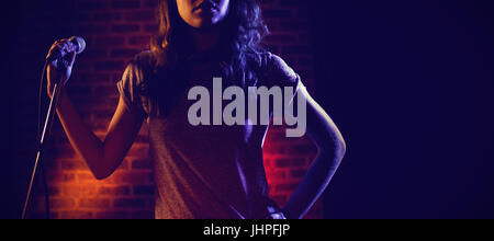 Female singer looking away while standing at nightclub Stock Photo