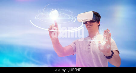Smiling young man using virtual reality glasses against view of blue sky and cloud Stock Photo