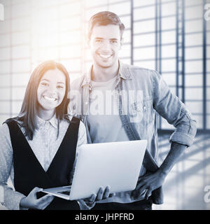 Smiling teamwork looking at camera against room with large window overlooking city Stock Photo