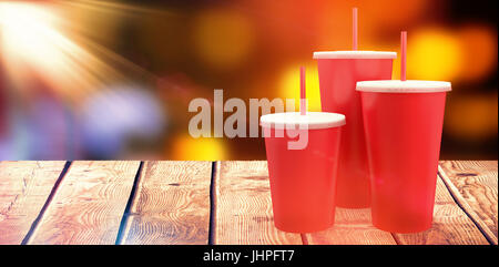 Red cups over white background against defocused image of illuminated orange lights Stock Photo