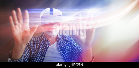 Senior man using virtual reality glasses against view of office corridor and workspace Stock Photo