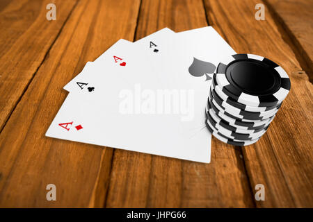 Circle casino tokens with playing cards against high angle of wooden planks Stock Photo