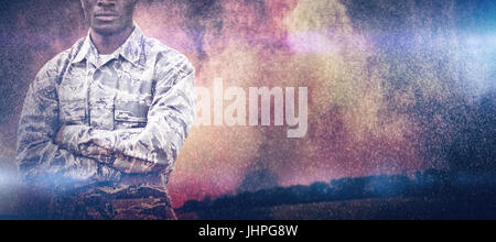 Wheat farm against full-length of military soldier with crossed arms Stock Photo