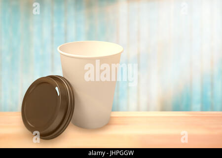 White cup in front of its cover against view of wooden planks Stock Photo