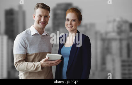Smiling business people using a digital tablet  against modern skyscrapers in city Smiling business people using a digital tablet against white backgr Stock Photo