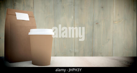 Disposable coffee cup and parcel bag  against wooden planks Stock Photo