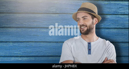 Smiling man standing with arms crossed against full frame shot of blue wall Stock Photo