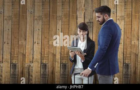 Business colleagues using digital tablet against wooden wall background Stock Photo