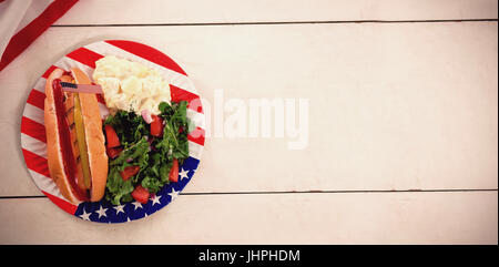 Overhead view of hot dog with American flag in plate on table Stock Photo