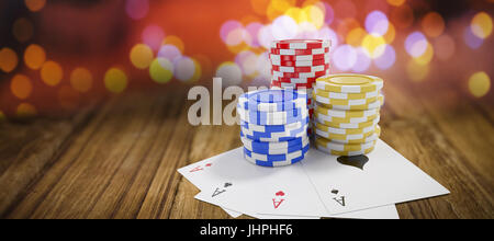 Tilt image of casino tokens with playing cards against wooden table Stock Photo