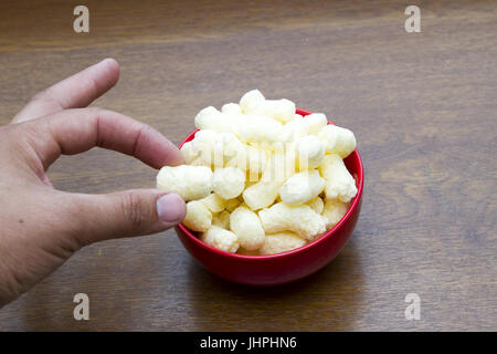 Corn sticks in saucer on wooden table. Hand Stock Photo