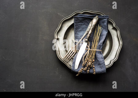 Table setting with dried lavender flowers in vintage style on dark table Stock Photo