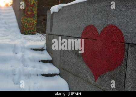 Red heart painted on grunge cement wall background - love concept Stock Photo