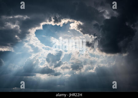 sun rays shining through dark cloud  sky - Stock Photo
