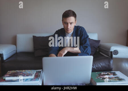 Man using laptop in living room at home Stock Photo