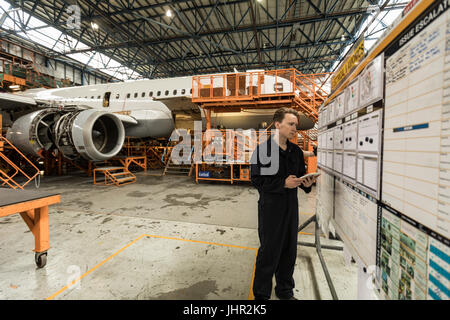 Male aircraft maintenance engineer using digital tablet at airlines maintenance facility Stock Photo