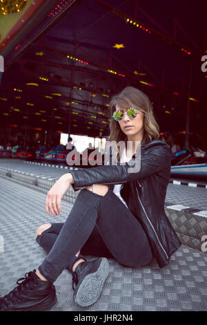 Beautiful woman sitting in amusement park Stock Photo