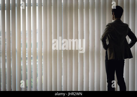 Businesswoman standing near the window in office Stock Photo