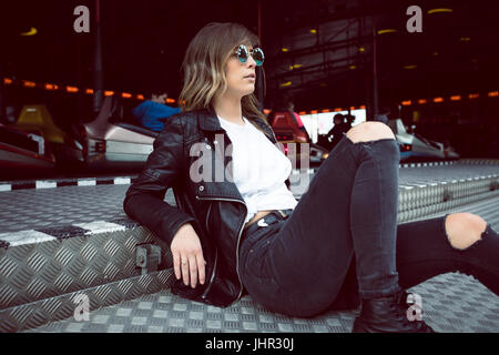 Stylish woman sitting in amusement park Stock Photo