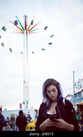 Beautiful woman using mobile phone in amusement park Stock Photo