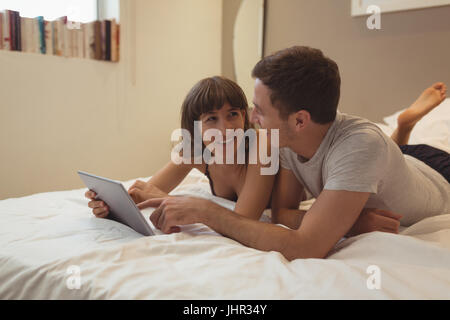 Couple using digital tablet in bedroom at home Stock Photo