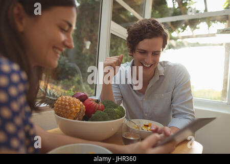 Smiling couple using digital tablet at home Stock Photo