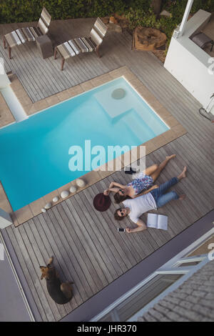 Smiling couple relaxing near pool side at home Stock Photo
