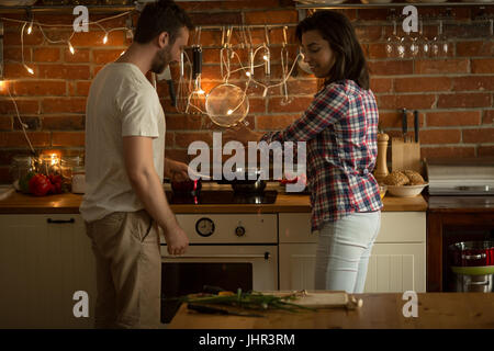 Happy couple preparing food in kitchen at home Stock Photo