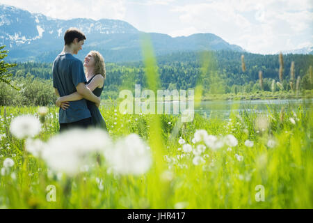 Couple embracing each other in countryside field on a sunny day Stock Photo
