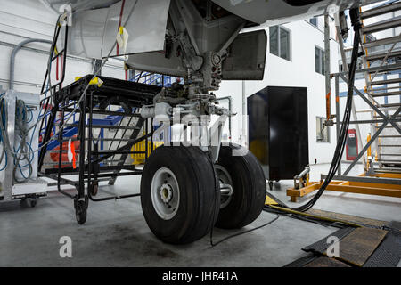 Close-up of chassis of the airplane under heavy maintenance at airlines maintenance facility Stock Photo