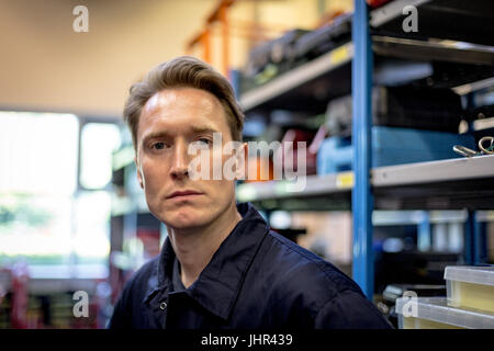 Portrait of female aircraft maintenance engineer standing at airlines maintenance facility Stock Photo