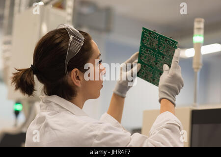 Female technician working on machine part at laboratory Stock Photo