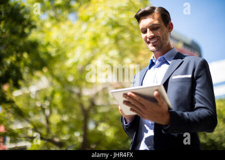 Smiling businessman using digital tablet on a sunny day Stock Photo