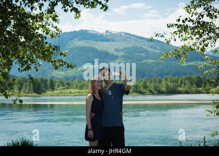 Happy couple taking selfie on mobile phone at countryside Stock Photo