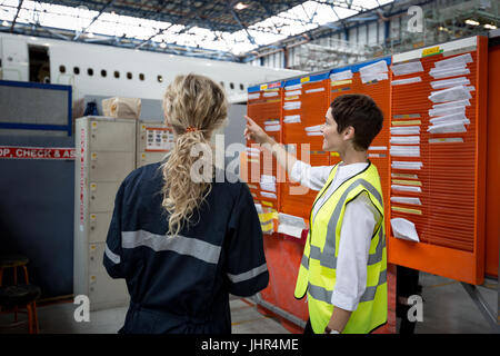 Female maintenance engineers interacting with each other at airlines maintenance facility Stock Photo