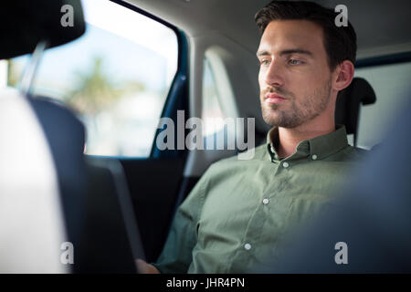 Man using laptop while traveling in car Stock Photo